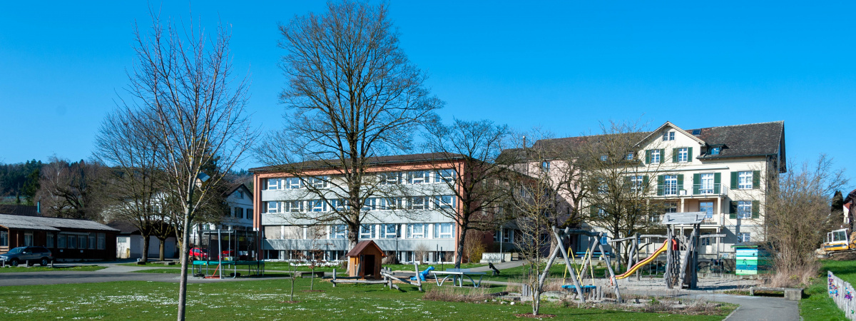 Schulhaus der Schuel Muure mit Spielplatz