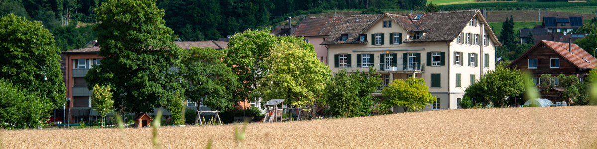 Das Sonderschulheim Mauren aus der Ferne mit vielen Bäumen darum